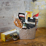 Perfect for sharing, this gift basket contains a selection of crackers, seasoned pretzels, maple popcorn, cookies, a truffle bar, red pepper jelly, and local fudge.